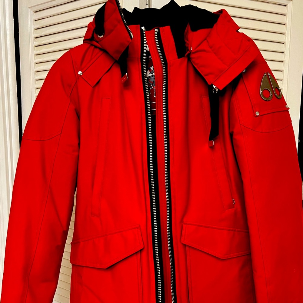 New with tags winter coat by Moose Knuckle has insulated hood with fur.